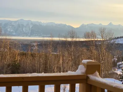 a snow covered balcony with a view of the mountains at Mountain Escape for Ski and Golf Enthusiasts in Kimberley