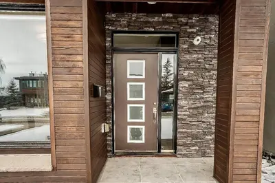 a door to a house with a brick wall at Luxury Cityscape Retreat with Hot Tub in Calgary