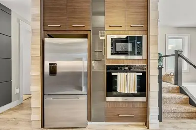 a kitchen with a stainless steel refrigerator and a microwave at Luxury Cityscape Retreat with Hot Tub in Calgary
