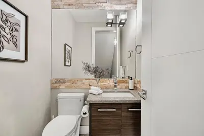 a bathroom with a toilet and a sink at Luxury Cityscape Retreat with Hot Tub in Calgary