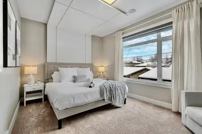 a bedroom with a bed with a teddy bear on it at Luxury Cityscape Retreat with Hot Tub in Calgary