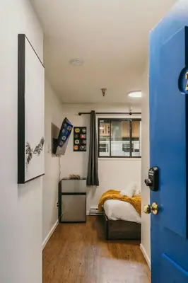 a small bedroom with a bed and a window at The Dorm Ski-In Ski-Out Studio, Pool and Gym in Big White