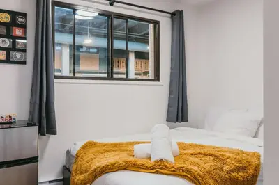 a bedroom with a bed with a blanket and a window at The Dorm Ski-In Ski-Out Studio, Pool and Gym in Big White