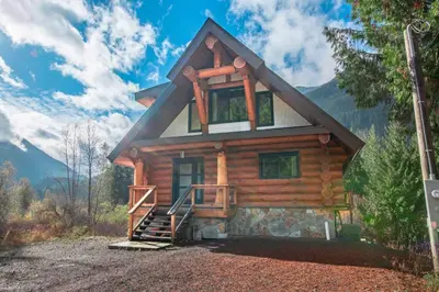 a log cabin in the mountains with a house at Douglas Fir Retreat, Mtn Views and Expansive Deck in Sunshine Valley