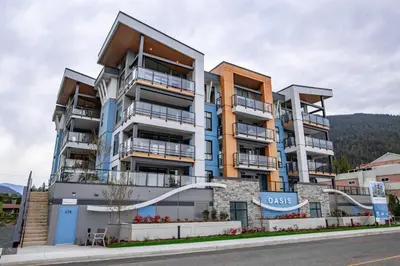 a large apartment building with balconies on a street at The Luna, New Penthouse w Patio, Lake and Mtn Views in Harrison Hot Springs