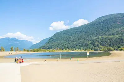 a group of people on a beach with mountains in the background at Harrison Lake Retreat, Studio Suite in Harrison Hot Springs