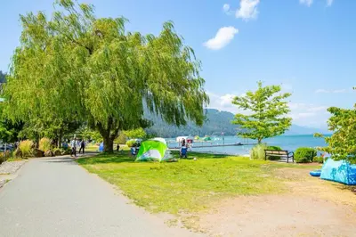 a park with tents on the grass near the water at Echo Beach, 2 Bed, Lake View and Walkable to Beach in Harrison Hot Springs