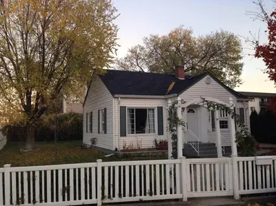 a white house with a white picket fence at Walk to the beaches and the restaurants downtown! in Kelowna
