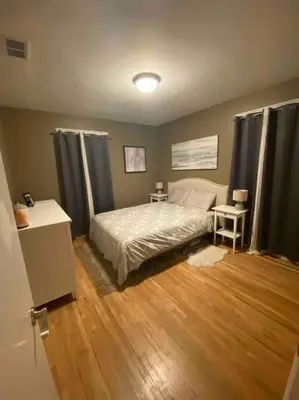 a bedroom with a bed and a wooden floor at Walk to the beaches and the restaurants downtown! in Kelowna