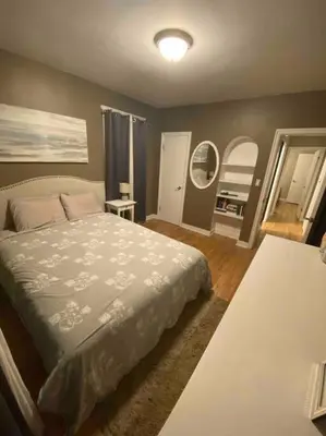 a bedroom with a bed and two mirrors at Walk to the beaches and the restaurants downtown! in Kelowna