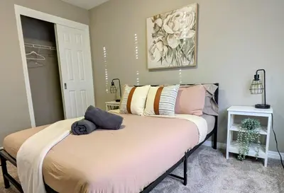 a bedroom with a bed with pillows on it at A Slice of Heaven in Airdrie by EaglesWingsHomes1 in Airdrie