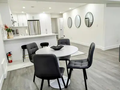 a dining room with a white table and chairs at A Slice of Heaven in Chestermere in Calgary