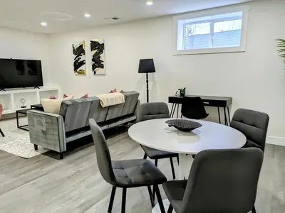 a living room with a couch and a table and chairs at A Slice of Heaven in Chestermere in Calgary