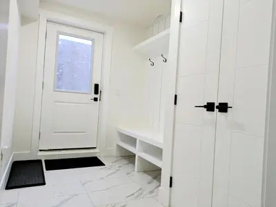 a white bathroom with a white door and a window at A Slice of Heaven in Chestermere in Calgary