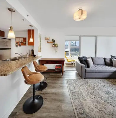 a kitchen and living room with a counter and a couch at Stylish Condo in Downtown in Vancouver