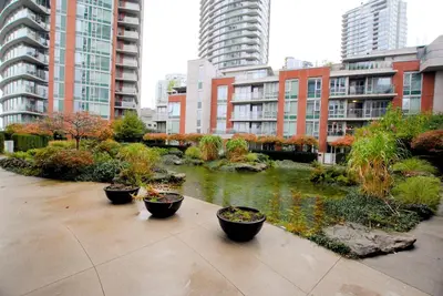 a garden with a pond in a city with tall buildings at Stylish Condo in Downtown in Vancouver