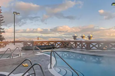 a swimming pool on top of a resort with snow at Stonegate Resort Unit A403 in Kelowna