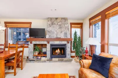 a living room with a fireplace and a table at Stonegate Resort Unit A104 in Big White
