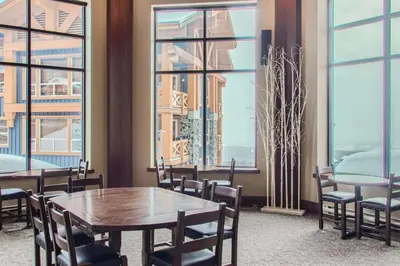 a dining room with tables and chairs and windows at Stonegate Resort Unit A104 in Big White