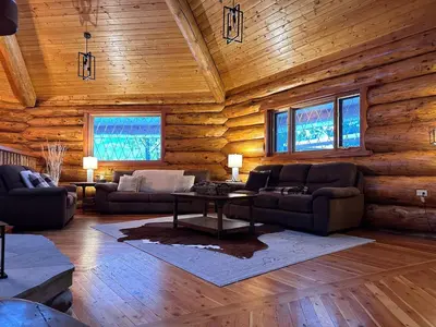 a living room with couches and a table in a log cabin at Ryders Lodge, Log Home in Edgewater, BC in Radium Hot Springs