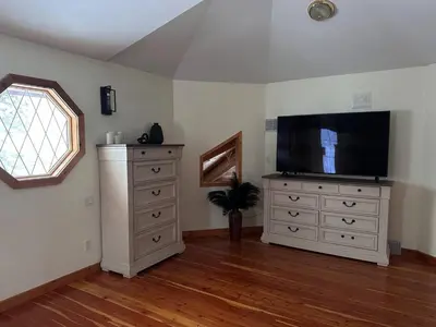 a living room with a flat screen tv and a dresser at Ryders Lodge, Log Home in Edgewater, BC in Radium Hot Springs
