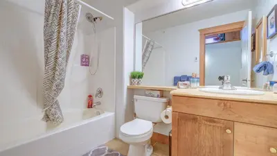 a bathroom with a toilet and a tub and a sink at Gone Ski 'Inn in Big White