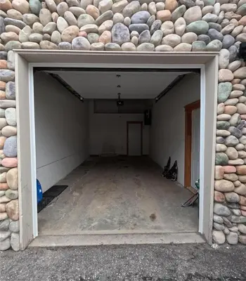 an empty garage with a stone wall and a doorway at Gone Ski 'Inn in Big White