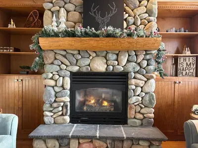 a living room with a stone fireplace at Gone Ski 'Inn in Big White