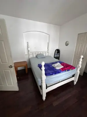 a small bedroom with a white bed in a room at Sam Estates in Calgary