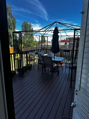 a deck with a table and chairs on it at Sam Estates in Calgary