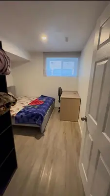 a bedroom with a bed and a desk and a door at Sam Estates in Calgary