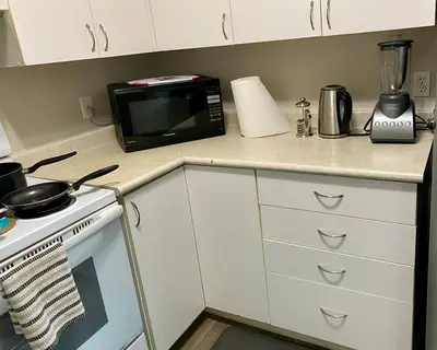 a kitchen counter with a microwave and a stove at All private 2 BRoom w 2 QUEEN BEDS-1 BTHRM-FREE PARKING-FAST WI-FI-CENTRAL LOCATION in Grande Prairie