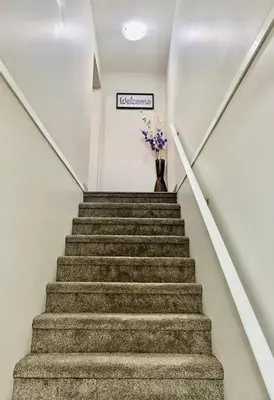 a stairway with a vase with flowers in it at All private 2 BRoom w 2 QUEEN BEDS-1 BTHRM-FREE PARKING-FAST WI-FI-CENTRAL LOCATION in Grande Prairie