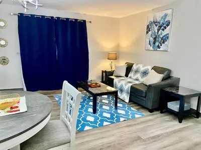 a living room with a couch and a table at All private 2 BRoom w 2 QUEEN BEDS-1 BTHRM-FREE PARKING-FAST WI-FI-CENTRAL LOCATION in Grande Prairie