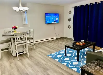 a living room with a table and a dining room at All private 2 BRoom w 2 QUEEN BEDS-1 BTHRM-FREE PARKING-FAST WI-FI-CENTRAL LOCATION in Grande Prairie