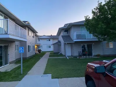 a house with a parking meter in front of it at All private 2 BRoom w 2 QUEEN BEDS-1 BTHRM-FREE PARKING-FAST WI-FI-CENTRAL LOCATION in Grande Prairie