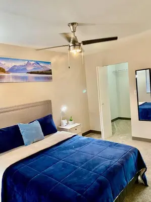 a bedroom with a blue bed and a ceiling fan at All private 2 BRoom w 2 QUEEN BEDS-1 BTHRM-FREE PARKING-FAST WI-FI-CENTRAL LOCATION in Grande Prairie