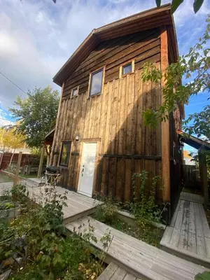 a wooden cabin with a front door and a deck at Located in Downtown Whitehorse - Basekamp in Whitehorse