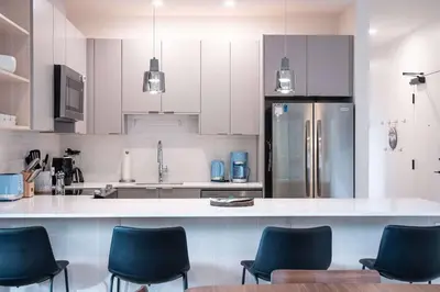 a kitchen with white cabinets and blue chairs at Alpine Retreat by Revelstoke Vacations in Revelstoke