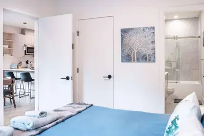 a bedroom with a blue bed and a kitchen at Alpine Retreat by Revelstoke Vacations in Revelstoke