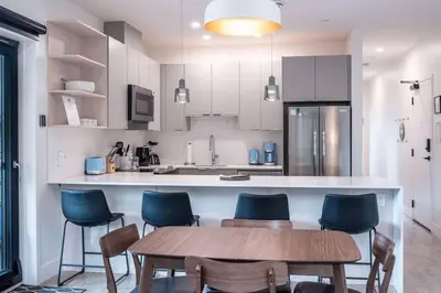 a kitchen with a wooden table and blue chairs at Alpine Retreat by Revelstoke Vacations in Revelstoke