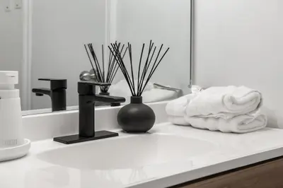 a bathroom sink with a towel and a vase on it at 3bd Luxury Home, Steps to Calgary DT, River, Hospital in Calgary