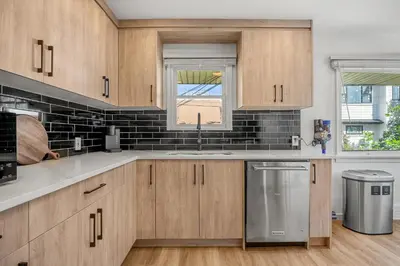 a kitchen with wooden cabinets and a sink at 3bd Luxury Home, Steps to Calgary DT, River, Hospital in Calgary