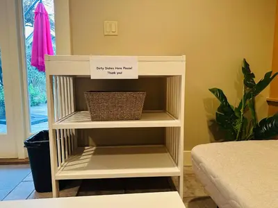 a white book shelf with a sign on it at Cozy Home in Dunbar in Vancouver