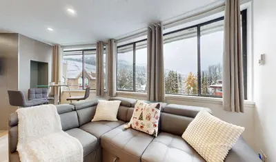 a living room with a couch and some windows at Whistler village central stay! in Whistler