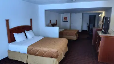 a hotel room with two beds and a flat screen tv at Metro Inn in Calgary