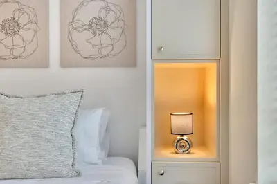 a bedroom with a bed and a nightstand with a lamp at Newly Renovated KING BED STUDIO in the Village in Whistler