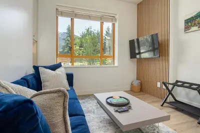 a living room with a blue couch and a table at Newly Renovated KING BED STUDIO in the Village in Whistler