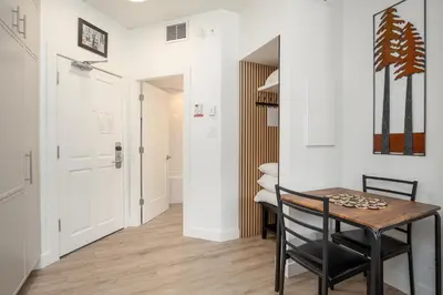 a small dining room with a table and a hallway at Newly Renovated KING BED STUDIO in the Village in Whistler