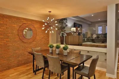 a dining room with a brick wall and a table and chairs at Ice District 2 Kings Underground Park Patio in Edmonton